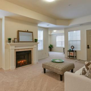 A cozy living room with a fireplace, comfortable seating, and soft lighting.