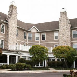A multi-story residential building with stone accents and well-maintained landscaping.