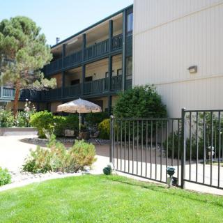 A view of an apartment building with balconies and a landscaped garden area.
