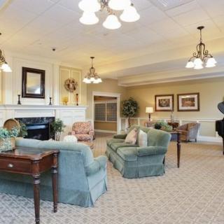 A spacious living room featuring elegant furniture, a fireplace, and a grand piano.