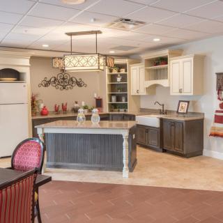 A modern kitchen with a central island and elegant lighting.