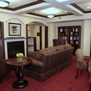 A cozy living room featuring a plush sofa, bookshelves, and a fireplace.