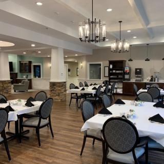 A well-decorated dining room with neatly arranged tables and elegant lighting.