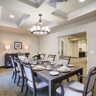 A modern dining room with elegant table settings and a stylish chandelier.