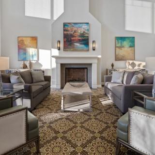 A stylish living room with a central fireplace, modern sofas, and decorative artwork.