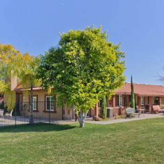 A beautiful suburban house with a spacious yard and vibrant greenery on a sunny day.