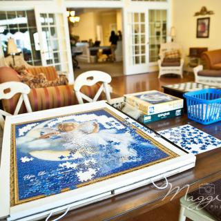 A cozy living room with a puzzle in progress on the table.