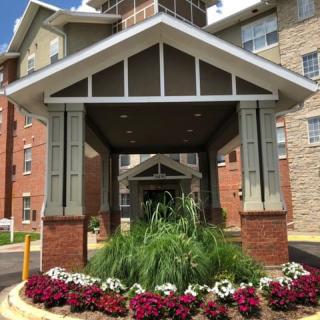 A building entrance with landscaped flowers and greenery.