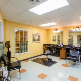 A well-lit hair salon with styling stations and chairs.