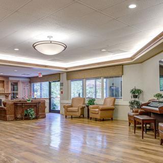 Spacious lounge area with comfortable seating and a piano.