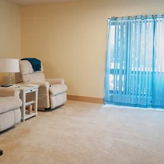 Cozy living room with recliners, a side table, and bright blue curtains.