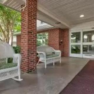 A covered entrance with benches outside a brick building.