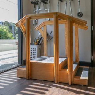 A wooden exercise structure inside a sunlit room.