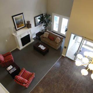 A cozy living room featuring comfortable seating, a fireplace, and large windows that fill the space with natural light.