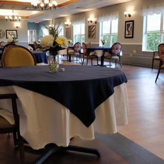 A well-decorated dining area with neatly arranged tables and chairs, featuring elegant table settings.