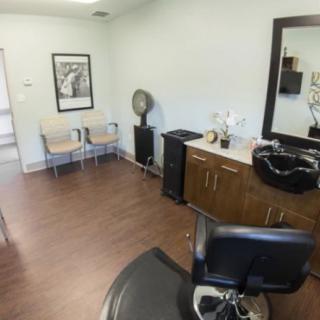 A cozy hair salon interior with a styling area and waiting space.
