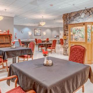A well-lit dining area with neatly arranged tables and chairs, featuring elegant interior decor.