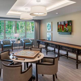 A modern game room with large windows, comfortable seating, and ample natural light.