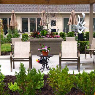 A well-designed outdoor patio area featuring comfortable furniture, lush plants, and elegant landscaping.