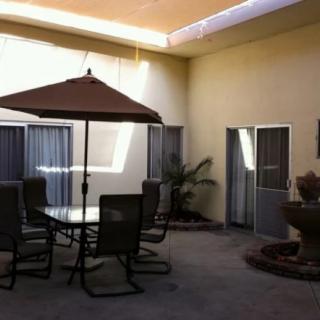 A cozy courtyard with a patio set and a water fountain.