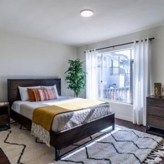 A modern and cozy bedroom with stylish decor and ample natural light.