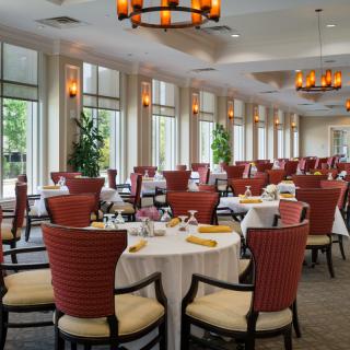 An elegantly decorated dining area with neatly arranged tables and chairs.