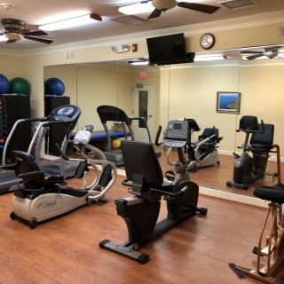A well-equipped gym with various exercise machines, including treadmills and stationary bikes.