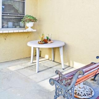 A cozy outdoor patio with a white round table and a decorative bench.
