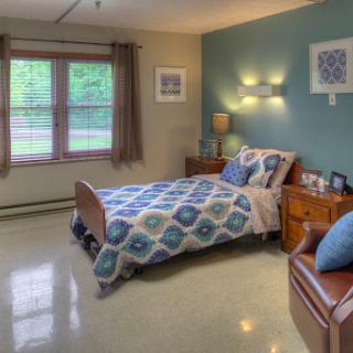 A cozy and well-lit bedroom featuring a comfortable bed, stylish decor, and natural light from the windows.