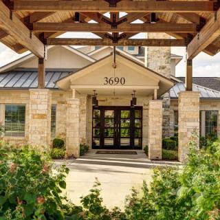 A welcoming entrance to a building with stone exterior and wooden beams.