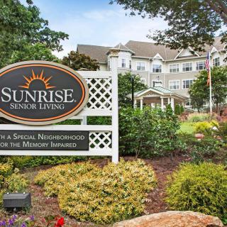 A well-landscaped entrance to a retirement home with a prominent sign.