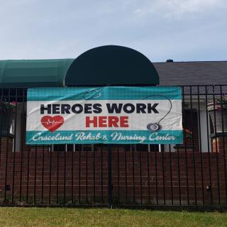 Banner outside a nursing center reading 'Heroes Work Here'.