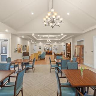 A spacious dining area with elegant decor and a central chandelier.