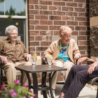 A group of seniors enjoying a conversation outdoors.