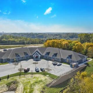 Aerial view of a residential building surrounded by trees and countryside.