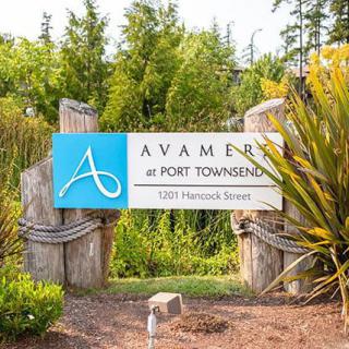 Entrance sign for Avamere at Port Townsend, surrounded by lush greenery.