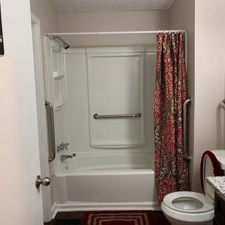 A clean bathroom with a bathtub, shower curtain, and toilet.