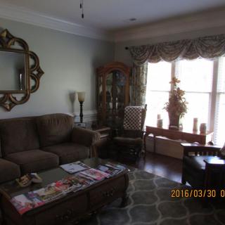 A cozy living room with a sofa, coffee table, and a window letting in natural light.
