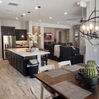 A modern open-concept living space with a kitchen and dining area featuring sleek decor elements.
