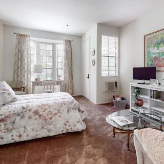 A cozy bedroom with floral bedding, ample natural light, and stylish decor.