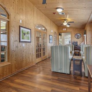 A cozy interior hallway featuring wooden paneling, restaurant booths, and ceiling fans.