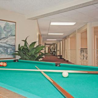 A pool table located in a spacious hallway, ready for a game.
