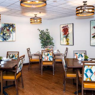 A stylish dining room featuring modern furniture and artistic decor.