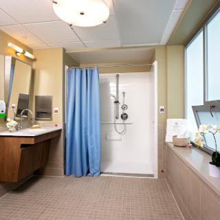 A modern bathroom featuring a shower, vanity area, and plenty of natural light.