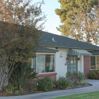 A suburban house with a well-maintained garden and trees.
