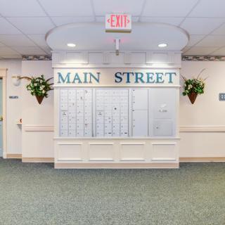 A hallway with a directory and 'Main Street' signage, decorated with hanging plants.