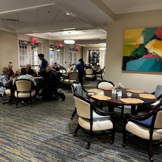 A lively dining area with patrons enjoying their meals and staff attending to them.