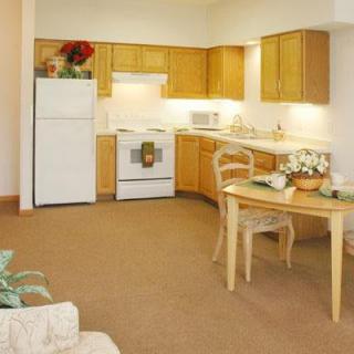 A cozy kitchen with wooden cabinets and a small dining table.