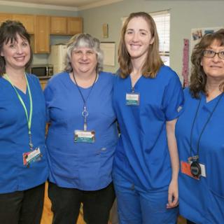A team of healthcare professionals posing together in their blue scrubs.