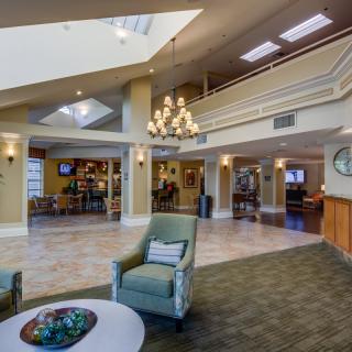 Spacious lobby with elegant chandelier and comfortable seating.